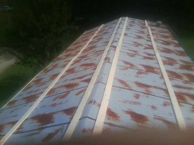 Rusted metal roof panels with new wood purlins before replacement — Storm Damage Roof Repair in Beccaria by Roofing Brothers